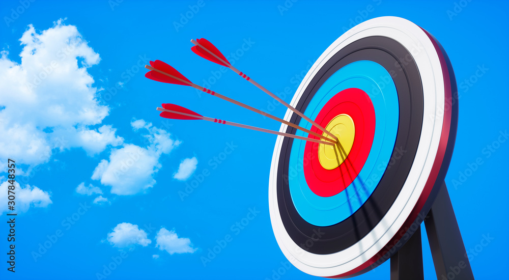 Colored target board with arrows in the sun against blue sky with small