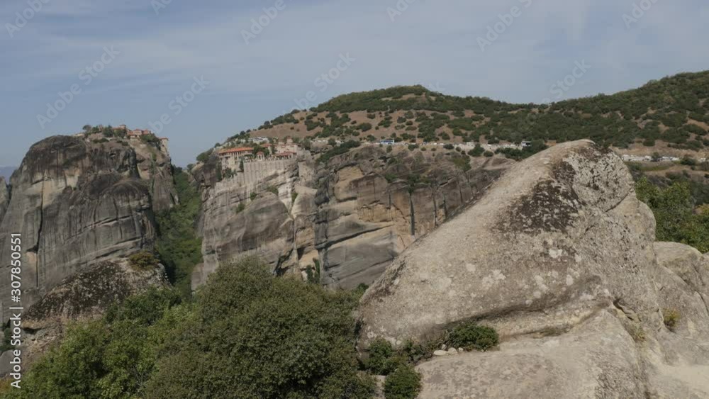 Tourists with cars and buses on Greek Meteora rock formations 4K panning video Tourists with cars and buses on Greek Meteora rock formations 4K panning video