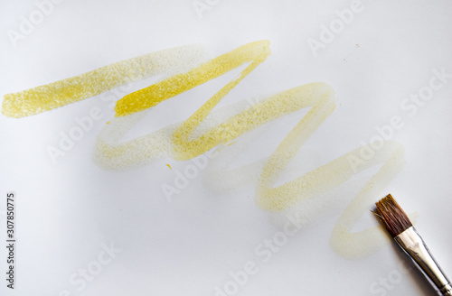 Brushes in yellow paint yellow ochre strokes of the paint brush isolated on a white, copy space, place for text  photo