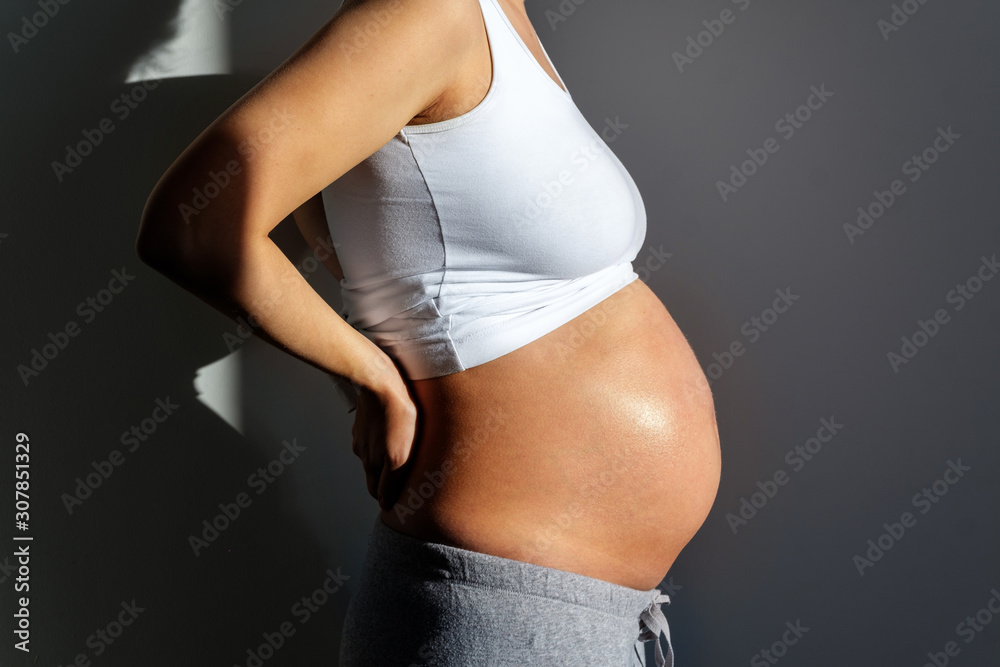 Fototapeta premium Belly of a pregnant woman close-up