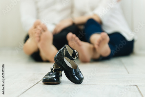 Baby shoes child on the background of bare feet parents