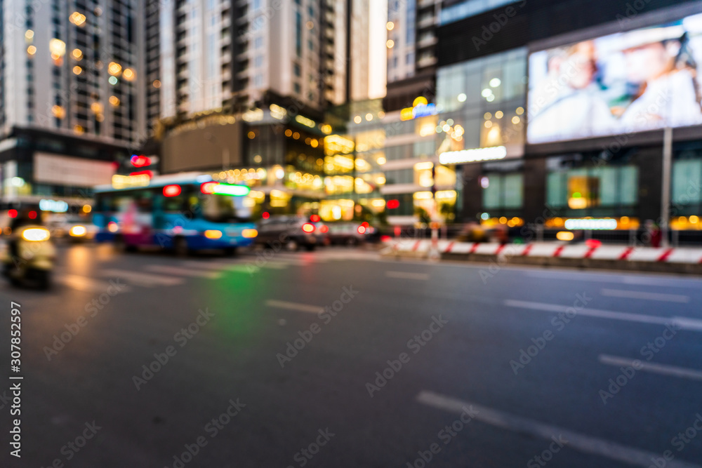 Hanoi cityscape at twilight with blurred asphalt road and modern buildings on background