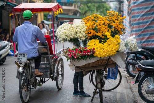 Flower vendor on Hanoi old town street at early morning