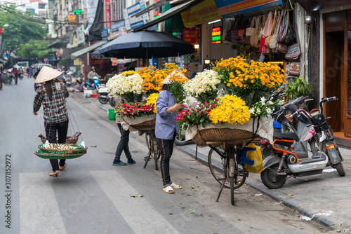 Flower vendor on Hanoi old town street at early morning