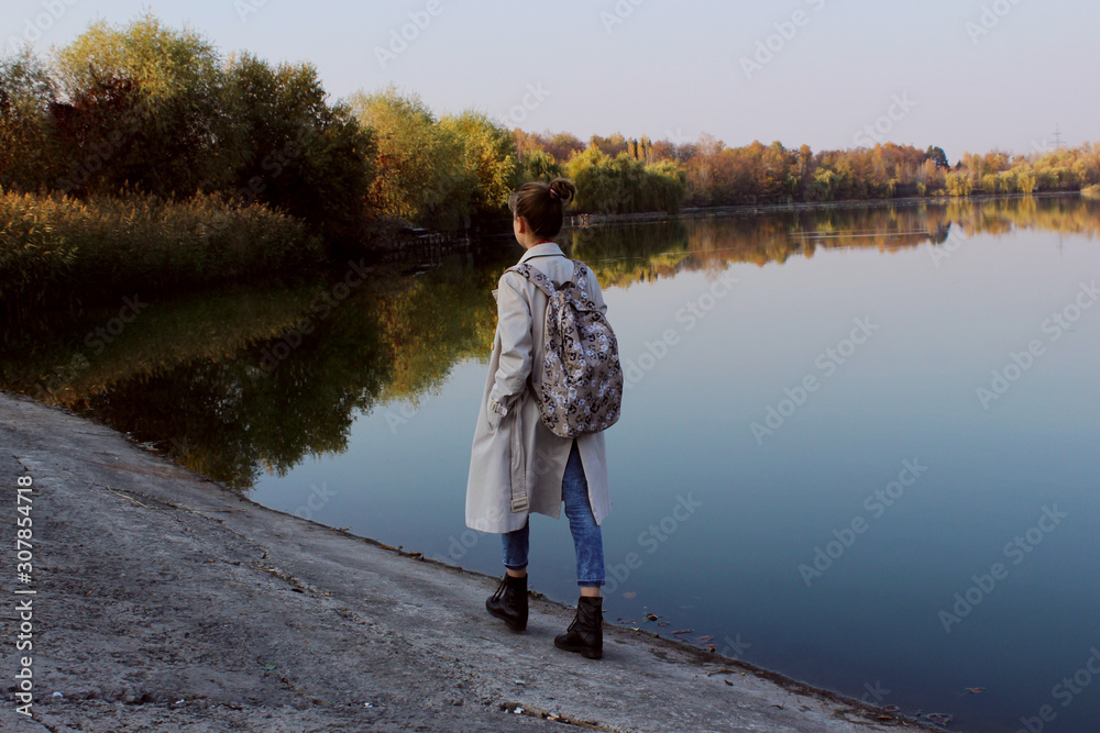 Fototapeta premium Full length portrait of young teenage girl walking near the lake. People, nature, travel concept.