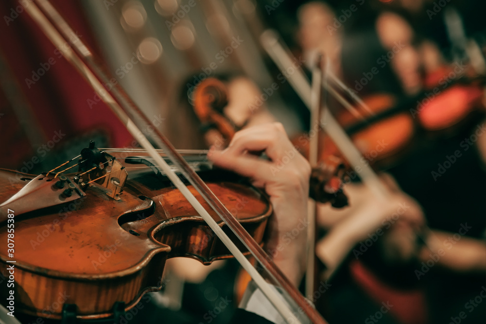 Symphony orchestra on stage, hands playing violin. Shallow depth of field, vintage style. - obrazy, fototapety, plakaty 