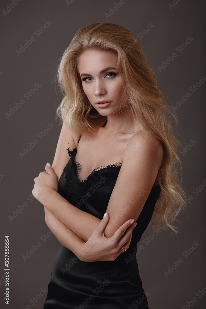 Naklejka premium Beautiful woman in black dress in studio