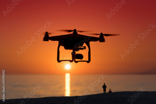 Silhouette of a quadrocopter on sunset background