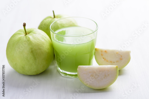 Green guava fruit and guava juice in glass on white background, high vitamin C healthy drink
