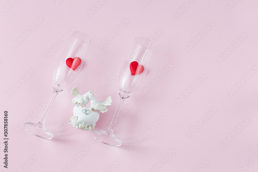 on a pink background, two glasses with hearts and a figure of two white doves in love on a pink background, two glasses with hearts and a figure of two white doves in love