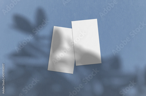 Business card Mockup on blue background. Natural overlay lighting shadows the leaves. Business cards 3.5x2 inch. Scene of Leaf Shadows.