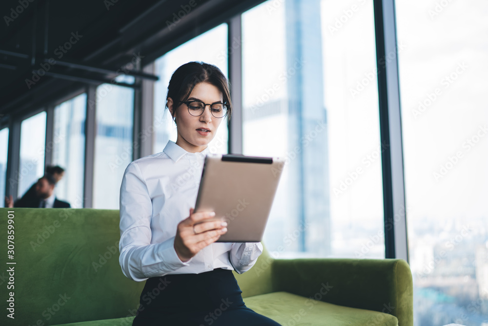 Young businesswoman browsing tablet in hall of company Young businesswoman browsing tablet in hall of company