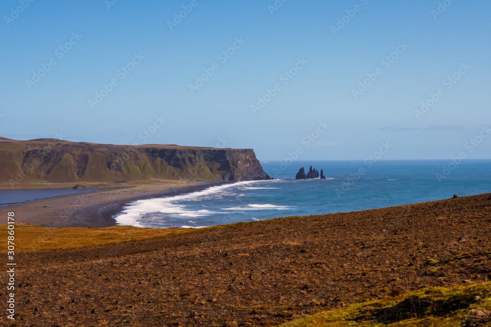 Famous Reynisdrangar rock formations at black Reynisfjara Beach. Coast of the Atlantic ocean near Vik, southern Iceland. September 2019