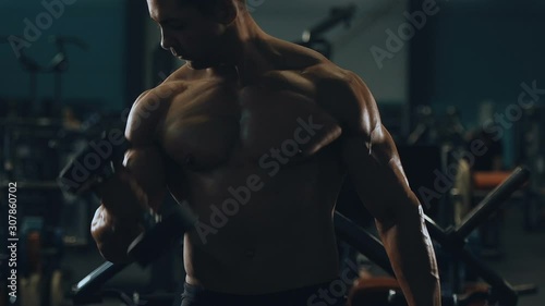 Bodybuilder handsome strong athletic man pumping up biceps muscles workout fitness and bodybuilding concept background - muscular fitness men doing arms exercises in gym naked torso