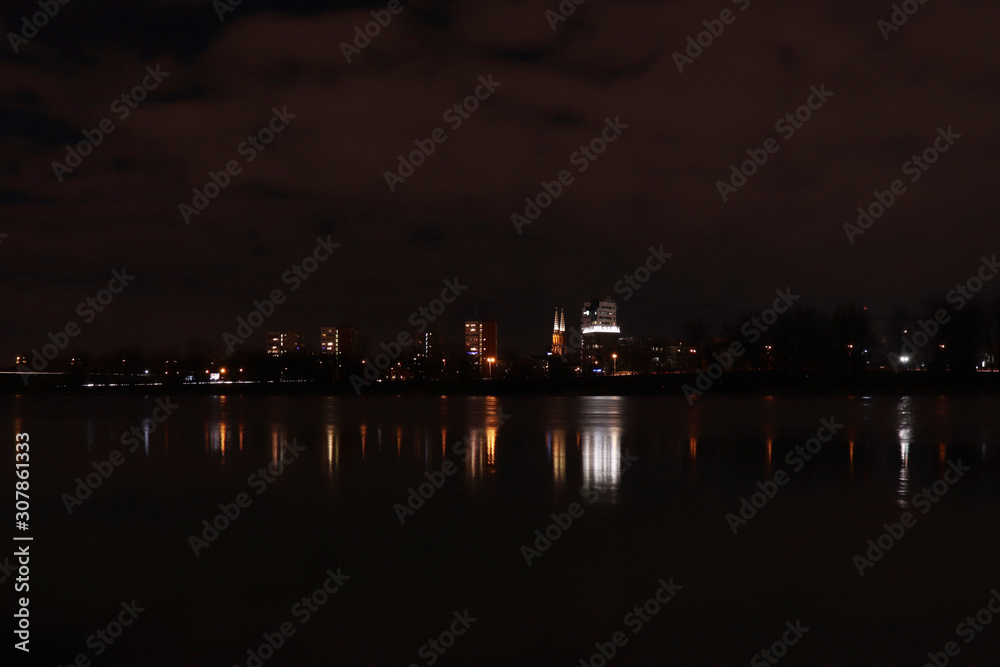 Lights on buildings reflected in the water in Warsaw, Poland