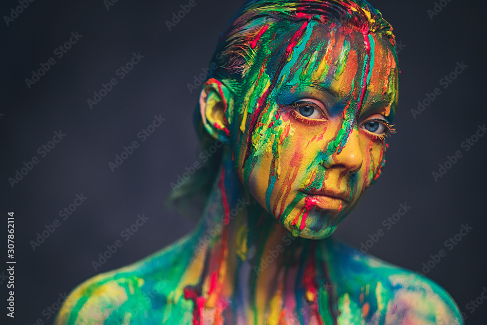 Young woman covered with a colourful paint Young woman covered with a colourful paint