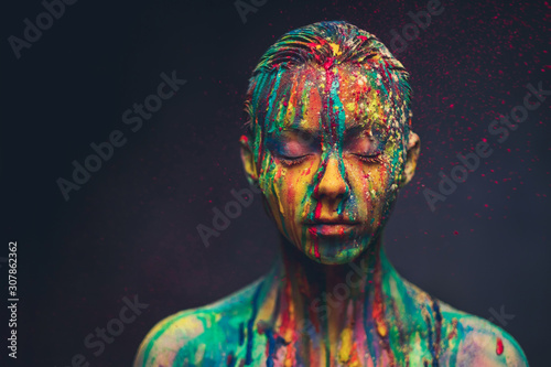 Young woman covered with a colourful paint