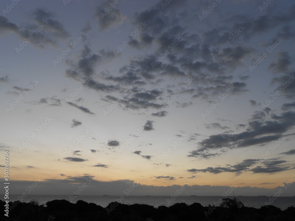 Fototapeta premium Scattered clouds with sunset seascape