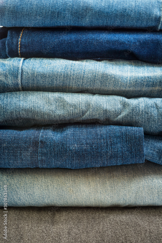 Stack of different blue jeans.