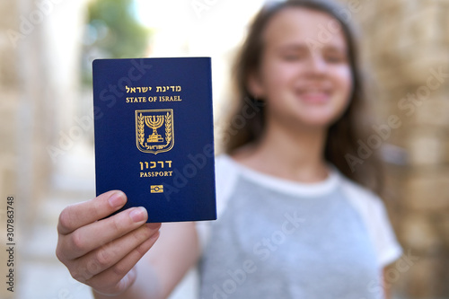 Cuadro en lienzo Happy teenage girl showing the passport of the State of Israel holding it in han