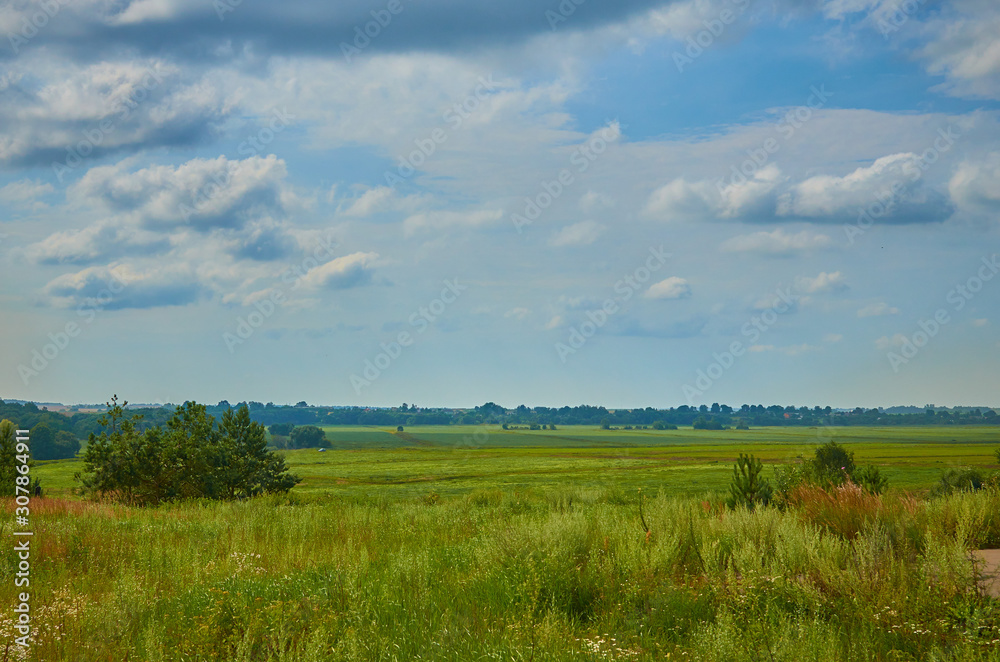 Peaceful rural summer european landscape with green trees and water