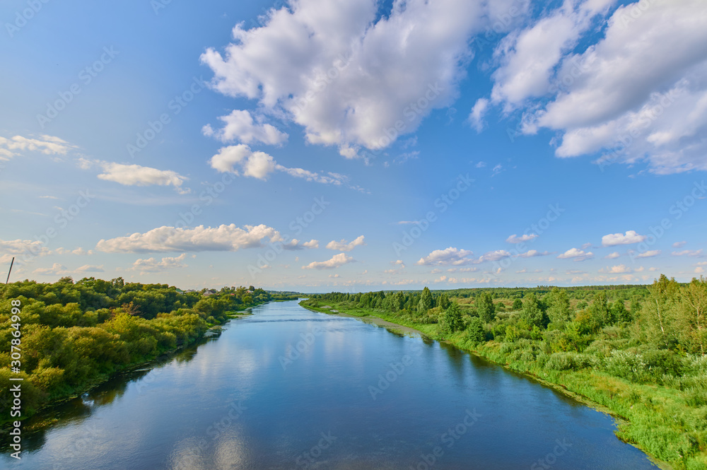 Peaceful rural summer european landscape with green trees and water