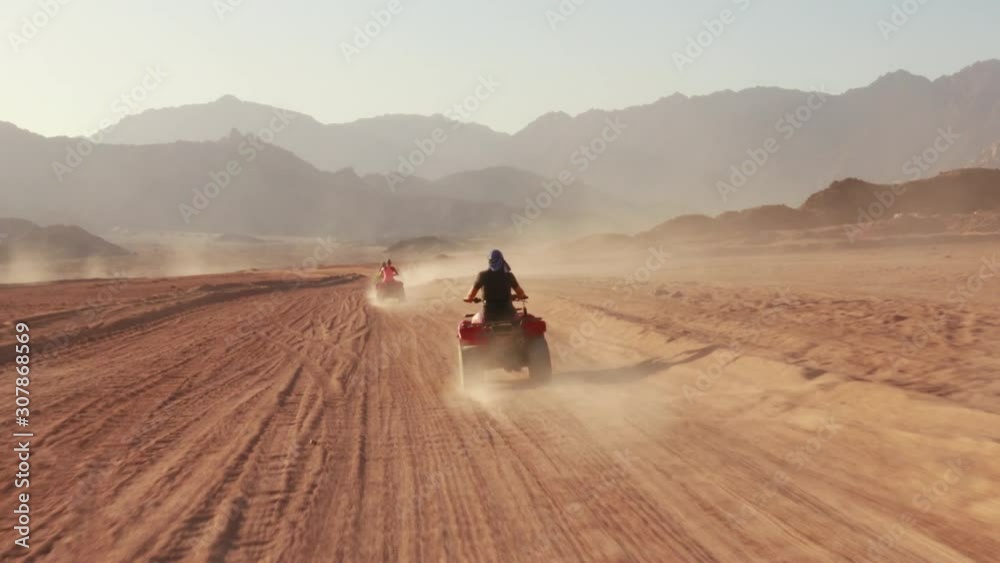Quad bike ride through the desert near Sharm el Sheikh, Egypt.Adventures of desert off-road on ATV.Sand and Sand Borkhan. Rock and sunset. Quad Cycle Travel. Excursion with people.