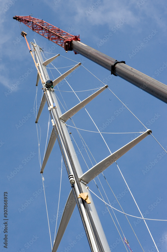 Masts of a super sailing yacht. Shipbuilding. Placing a mast on a ship. Crane