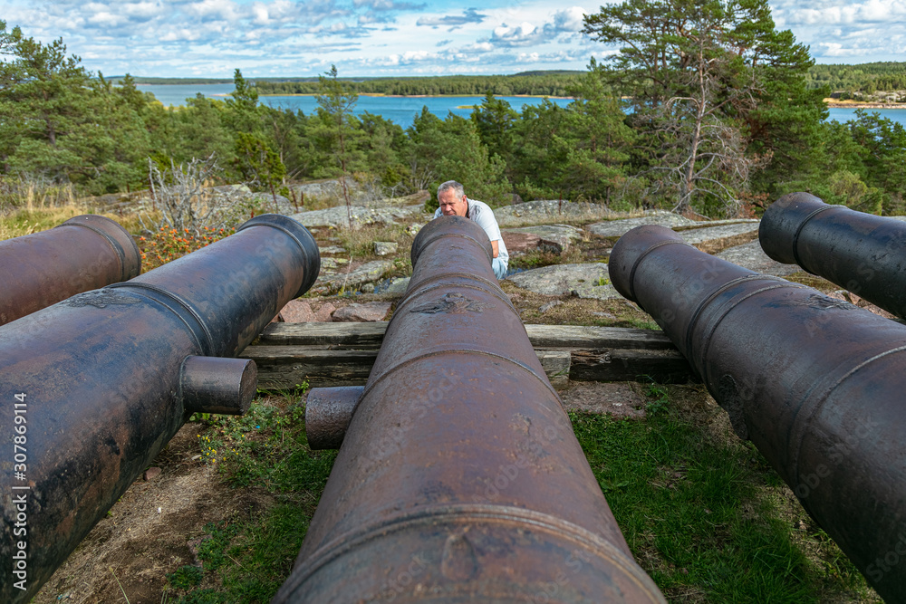 A man looks at the guns.