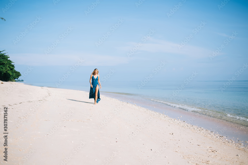 Woman walking along beautiful seashore