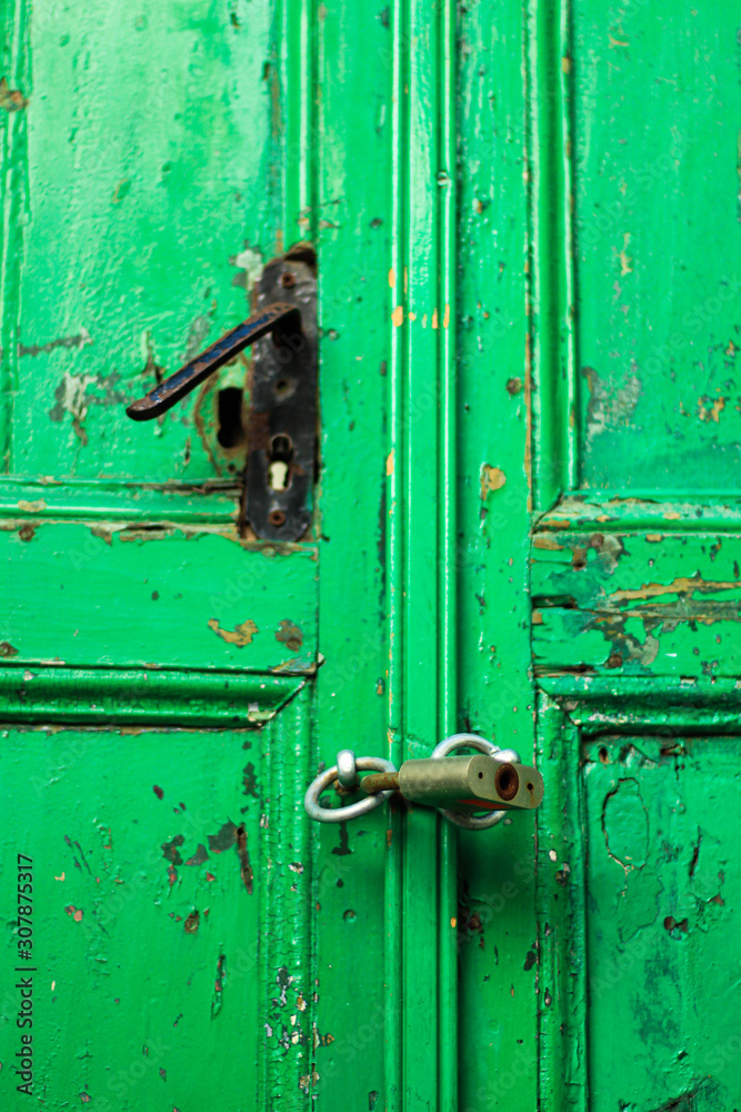 Green, old wooden door with lock, selective focus Green, old wooden door with lock, selective focus