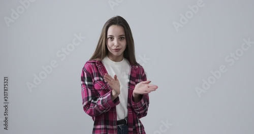 Bored teenage girl clapping hands in sarcastic way over white background
