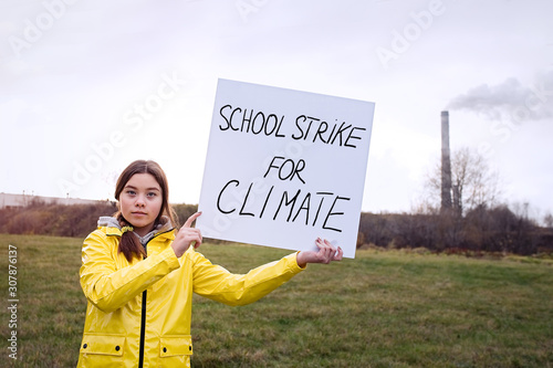 Teenager girl holding placard during global strike for climate change      photo