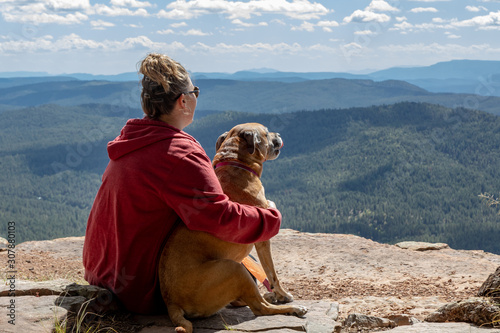 Young woman with dog resting after hiking photo