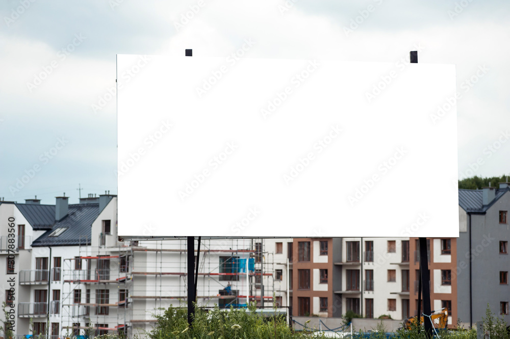 Blank white advertising billboard in the front of construction site on residential area Blank white advertising billboard in the front of construction site on residential area