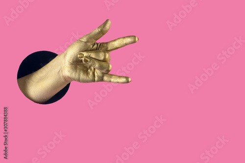 Hand painted in gold shows different gestures and symbols from the hole on a pink pastel paper background.
