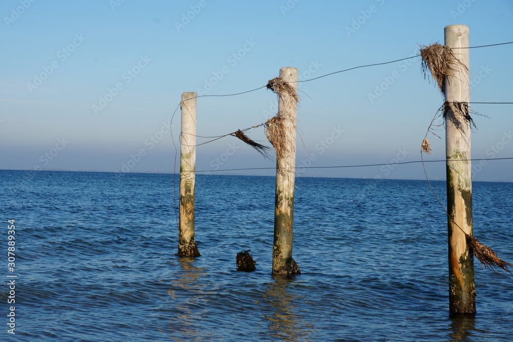 Obraz premium Holzzaun im Meer