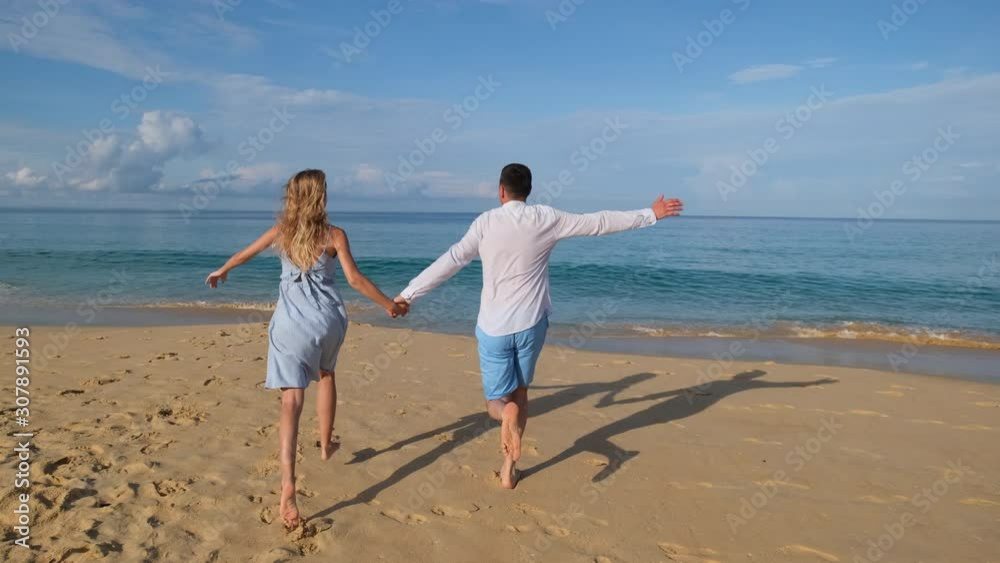 newly married couple in honeymoon trip running at beach. happy family vacation tourism travel. traveler man woman girl running outdoors. tourists in tropical sea ocean sand surf holiday slow-mo, 4 K newly married couple in honeymoon trip running at beach. happy family vacation tourism travel. traveler man woman girl running outdoors. tourists in tropical sea ocean sand surf holiday slow-mo, 4 K