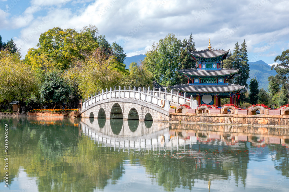 Beautiful view of the Jade Dragon Snow Mountain and the Suocui Bridge over the Black Dragon Pool in the Jade Spring Park, Lijiang,