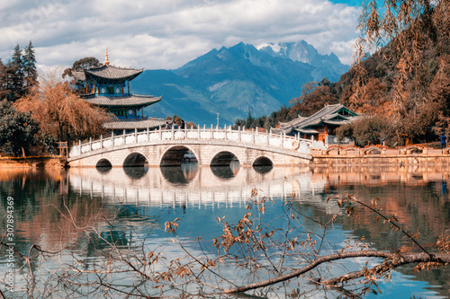 Beautiful view of the Jade Dragon Snow Mountain and the Suocui Bridge over the Black Dragon Pool in the Jade Spring Park, Lijiang, photo