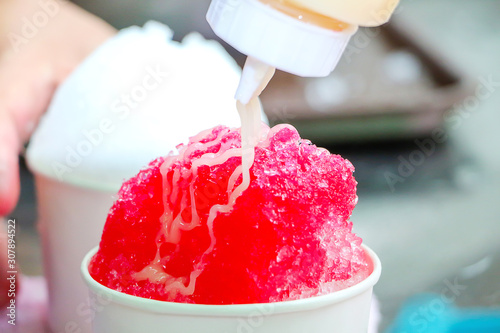Red shaved ice that is clear condensed milk is hot in the summer