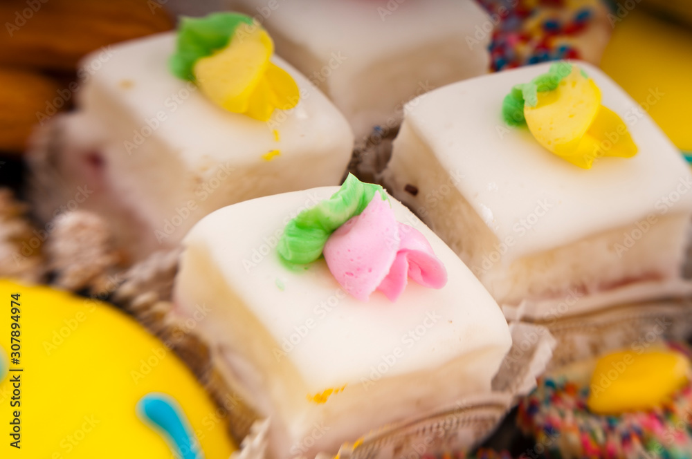 Bakery display closeup of iced petit fours small cakes Bakery display closeup of iced petit fours small cakes