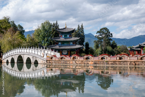 Beautiful view of the Jade Dragon Snow Mountain and the Suocui Bridge over the Black Dragon Pool in the Jade Spring Park, Lijiang,