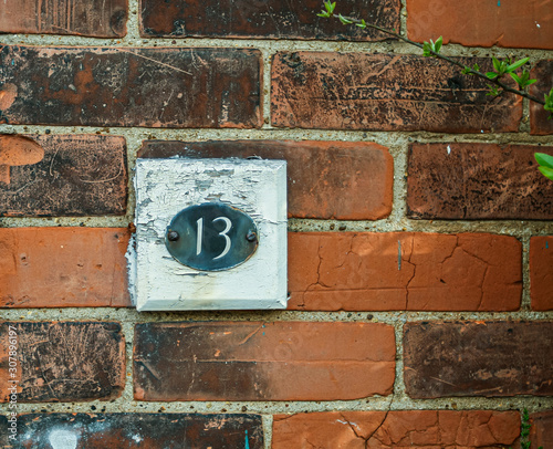 A weathered house number 13