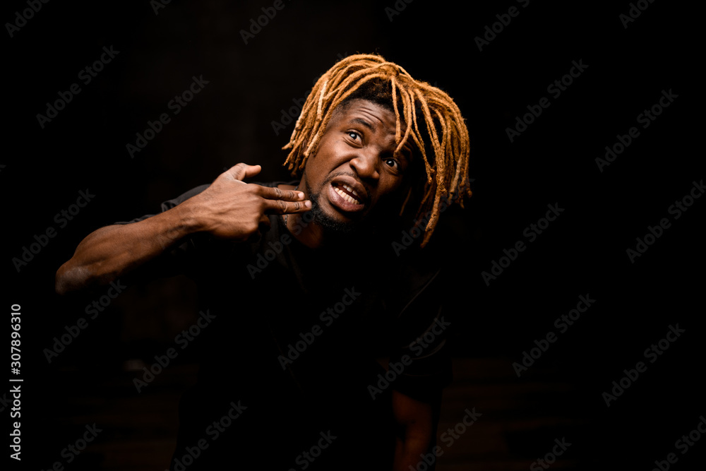 Afro american guy points with fingers at his jaw Afro american guy points with fingers at his jaw