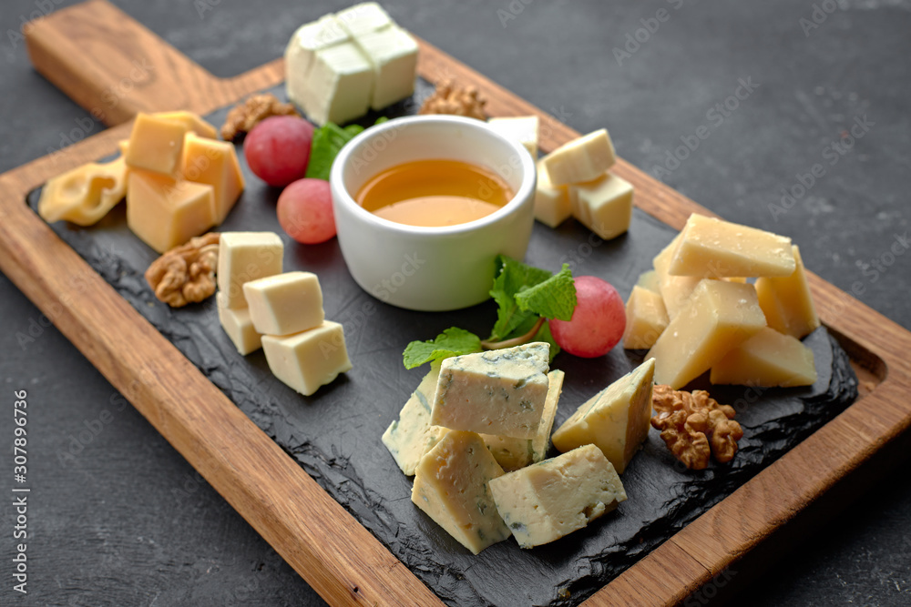 Fototapeta premium Assorted cheese (cheese board) on a black background