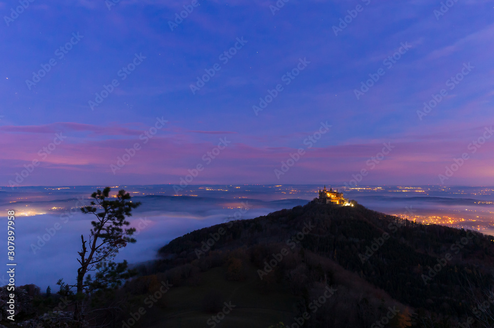 Burg Hohenzollern mit Beleuchtung am frühen Morgen kurz vor Sonnenaufgang  mit Nebel – Stock-Foto | Adobe Stock