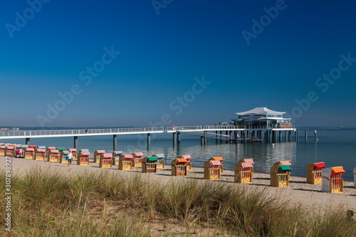 Beach baskets at Timmendorfer Strand with Seeschloesschenbruecke and Japanese teahouse, Luebeck Bay, Baltic Sea, Schleswig-Holstein, Germany