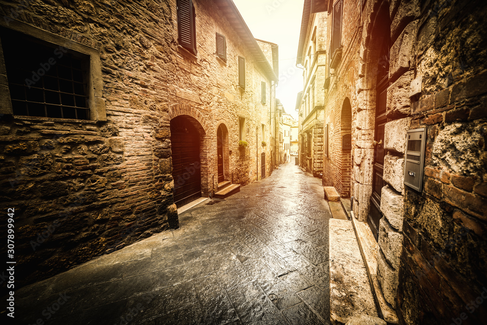 Narrow street in an old village in Tuscany at sunset