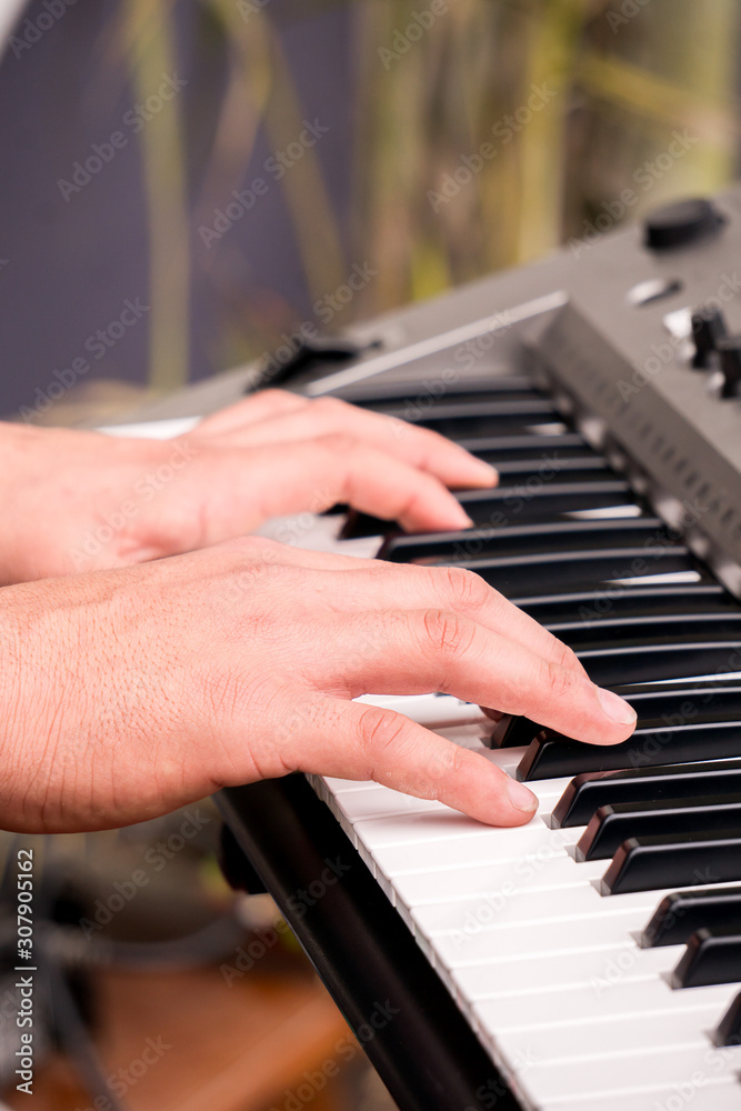 Obraz premium hands pressing keys while playing the electronic piano.